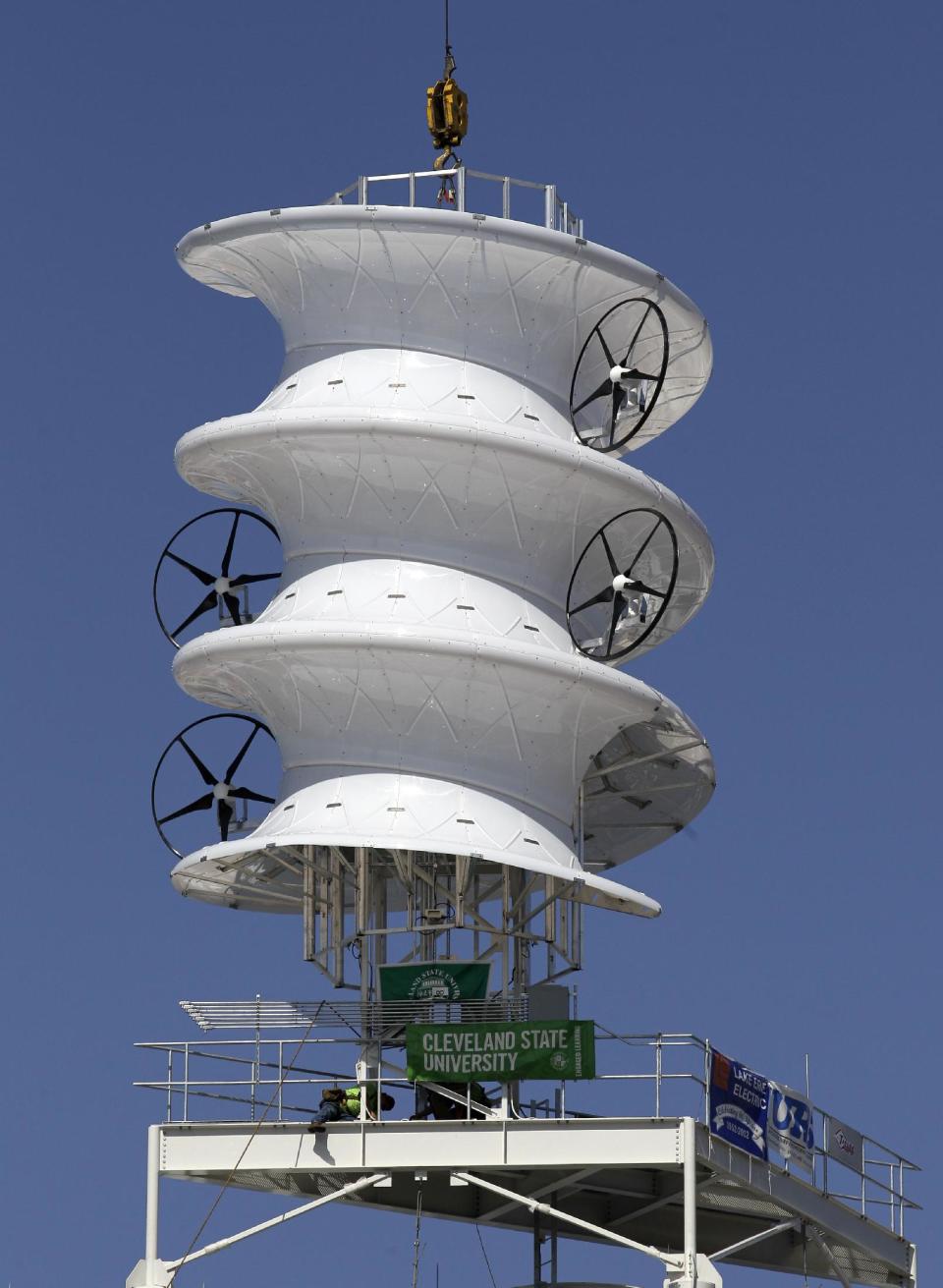 Workers attach a wind turbine to top of the southeast corner of Progressive Field, home of baseball's Cleveland Indians, in Cleveland on Wednesday, March 28, 2012. The Indians are the first major league team to install a wind turbine. The innovative corkscrew-shaped structure, which was designed at Cleveland State and funded by grants from the U.S. Department of Energy and state, will be operating by opening day on April 5. (AP Photo/Amy Sancetta)