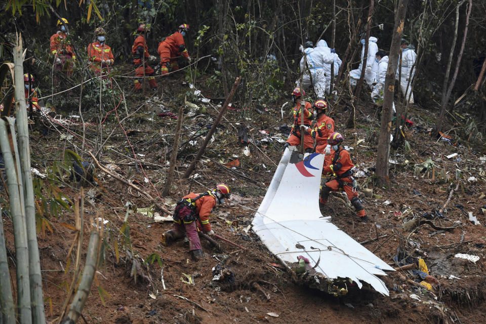 FILE - In this photo released by Xinhua News Agency, search and rescue workers search through debris at the China Eastern flight crash site in Tengxian County in southern China's Guangxi Zhuang Autonomous Region on March 24, 2022. Experts still are investigating the cause of the crash of a China Eastern Airlines jetliner that plunged into a mountainside one year ago, killing more than hundred people aboard, the government said on Monday, March 20, 2023. (Lu Boan/Xinhua via AP, File)