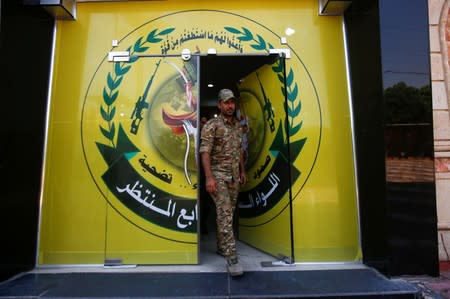 A member of Iraqi Popular Mobilisation Forces (PMF) walks out from the headquarters of the seventh brigade in Basra