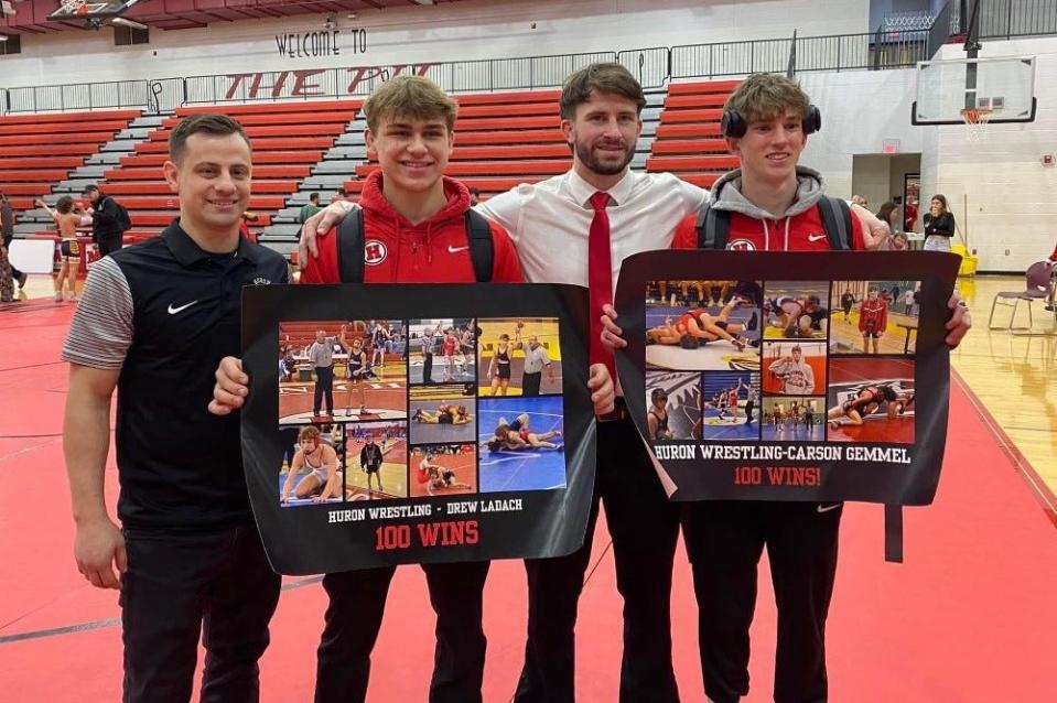 New Boston Huron assistant wrestling coach Jeremy Szekely (left) and head coach Logan Ritchie celebrate with two of their wrestlers who recently reached 100 career wins - Drew Ladach and Carson Gemmel (right). Gemmel got No. 100 Wednesday against Airport.