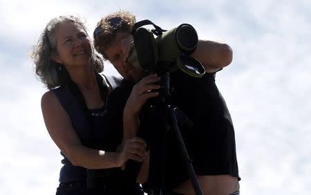 Cindy Butler and her boyfriend Jesse Beebe use a spotting scope to view a grizzly bear near Swan Lake in Yellowstone National Park, Wyoming, June 22, 2011. REUTERS/Jim Urquhart