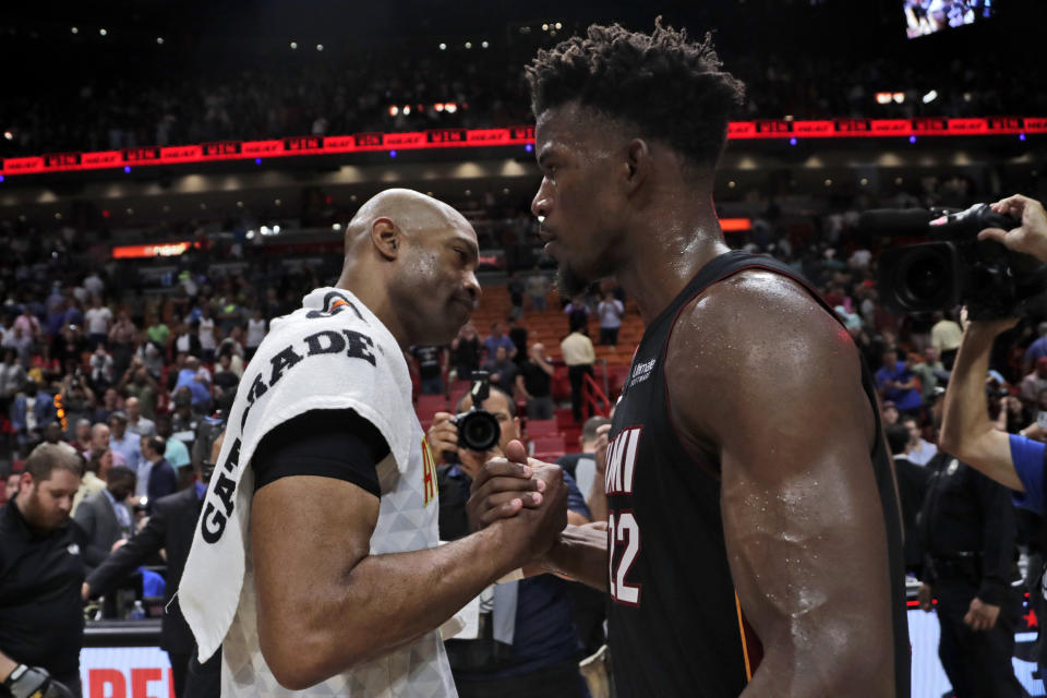 Atlanta Hawks guard Vince Carter, left, shakes hands with Miami Heat forward Jimmy Butler after an NBA basketball game, Tuesday, Dec. 10, 2019, in Miami. The Heat won 135-121 in overtime. (AP Photo/Lynne Sladky)