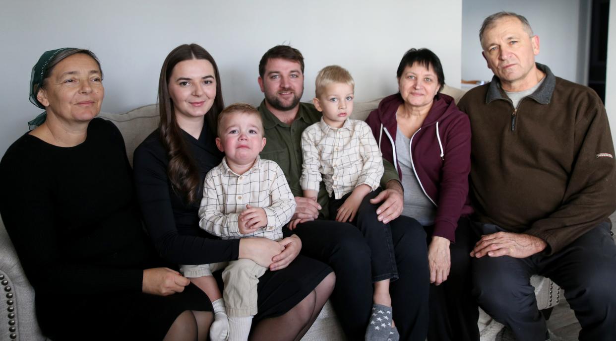 Having moved here from Ukraine, Daniela Shobei holds her son Lucas as her husband, Vitalii Shobei, holds their son Martin, flanked by their parents Nov. 10, 2023, in their rented house in Goshen. On the left is Daniela's mom, Tamara Holod, and on the right are Vitalii's parents, Natalia and Vasil Shobei.