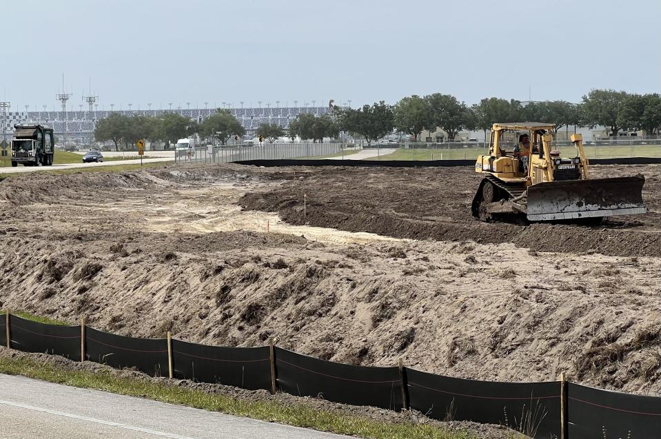 Land is being cleared along the north side of the Bellevue Avenue Extension at Daytona Beach International Airport east of Daytona International Speedway (visible in the distance) on Friday, May 10, 2024. The 54 acres, which previously was just a grass field, is being prepared for future aviation/airline-related commercial development, thanks to a $5 million grant from the U.S. Economic Development Administration.