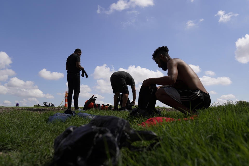 Migrants gather their personal items as they wait to be processed by the Border Patrol after illegally crossing the Rio Grande river from Mexico into the U.S. at Eagle Pass, Texas, Friday, Aug. 26, 2022. The area has become entangled in a turf war between the Biden administration and Texas Gov. Greg Abbott over how to police the U.S. border with Mexico. (AP Photo/Eric Gay)