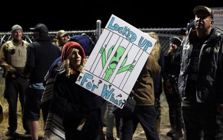 A woman carries a sign outside a gate to Area 51 as an influx of tourists responding to a call to 'storm' Area 51, a secretive U.S. military base believed by UFO enthusiasts to hold government secrets about extra-terrestrials, is expected in Rachel