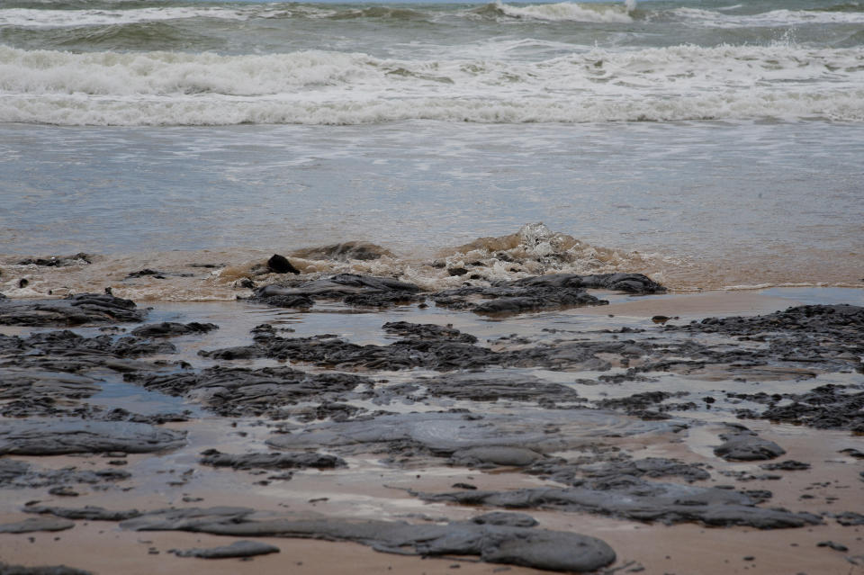 In this Sept. 25, 2019 photo released by the Sergipe state Government, an oil spill covers a beach on Sergipe state, Brazil. The spill started landing on Brazil's northeastern coast at the beginning of Sept., authorities say, and have now reached 61 municipalities in nine states, contaminating over 130 beaches. (Sergipe State Government via AP)