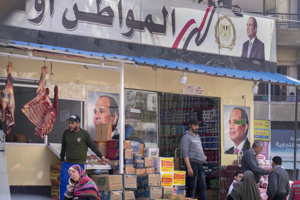 Clients buy groceries at a government sponsored shop fronted with Egyptian President Abdel Fattah el-Sissi posters in Cairo, Egypt, Monday, Feb. 27, 2023. Egypt is embarking on a privatization push to help its cash-strapped government, after pressure from the International Monetary Fund. The new policy is supposed to be a serious departure for the Egyptian state, which has long maintained a tight grip over sectors of the economy. (AP Photo)