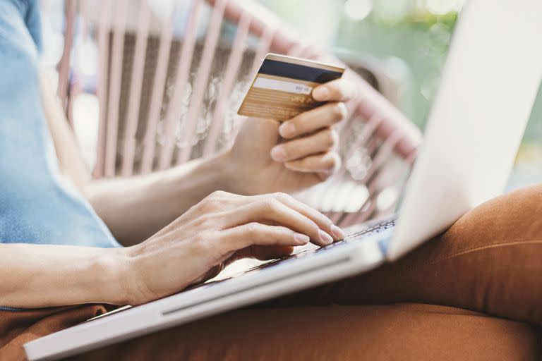 Young woman holding credit card and using laptop computer. Travel, business, internet banking, e-commerce and online shopping concept