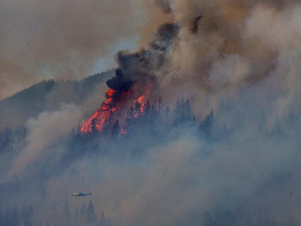 A helicopter flies along the flank of a wildfire in the Coburg Hills east of Interstate 5 north of Eugene.