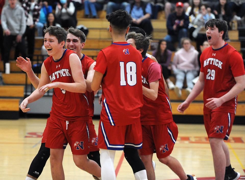 Natick High School volleyball players, including from left, sophomore captain Harrison Landry, senior captain Kendall Jackson, sophomore Matthew Salerno,  and junior Thomas Sweeney, right, celebrate winning a set against Milford,  May 2, 2022.