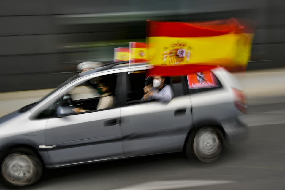 People wave Spanish flags during a drive-in protest organised by Spain's far-right Vox party against the Spanish government's handling of the nation's coronavirus outbreak, in Pamplona, northern Spain, Saturday, May 23, 2020. (AP Photo/Alvaro Barrientos)