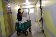 Volunteer Kingsley Ellis delivers food items from a local food bank to Sam, a resident in Dennison Point tower block, as the spread of the coronavirus disease (COVID-19) continues, in east London