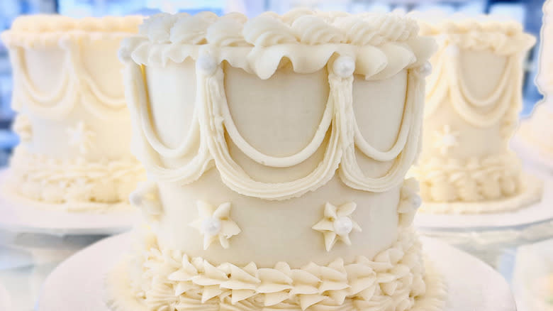 three decorated white cakes