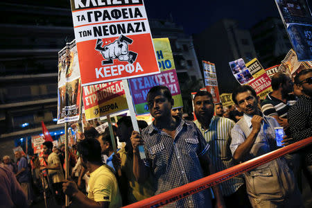 Migrants take part in an anti-fascist rally marking four years since the fatal stabbing of Greek rapper Pavlos Fyssas by a supporter of the ultranationalist Golden Dawn party in Athens, Greece, September 16, 2017. The placard reads "Close down the offices of the neonazis." REUTERS/Alkis Konstantinidis