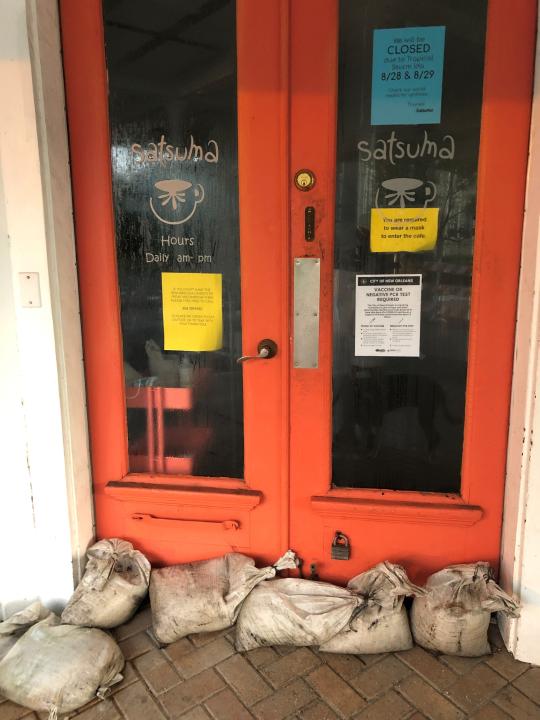 Sandbags are in place at Satsuma restaurant in New Orleans on Saturday, Aug. 28, 2021. Normally bustling on a weekend morning, the popular breakfast spot was closed while taking protections against possible flash floods as Hurricane Ida approached the Louisiana coast. (AP Photo/Kevin McGill)