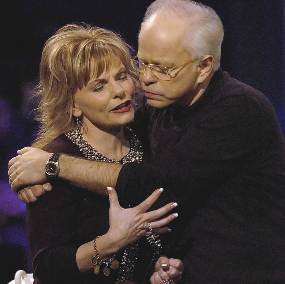 FILE - In this Friday, Dec. 30, 2005 file photo, televangelist Jim Bakker, founder of the former Heritage USA resort, holds his wife, Lori Graham Bakker, as they pray following his sermon, during the MorningStar Fellowship Church New Year's Conference, in Fort Mill, S.C. Bakker gained notoriety in the late 1980s and 1990s as a result of his trial and financial fraud conviction relating to Heritage USA. He moved to southwest Missouri in 2003. (Jeff Siner/The Charlotte Observer via AP)