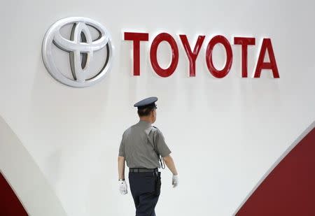 A security guard walks under the logo of Toyota Motor Corp at the company's showroom in Tokyo June 17, 2014. REUTERS/Yuya Shino