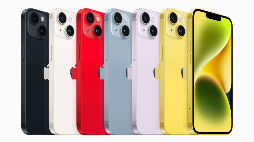 Seven iPhone 14s lined up in a range of colours