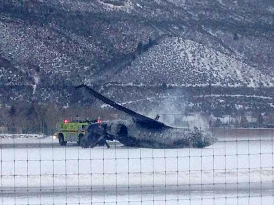 Emergency crews respond as a small plane lies on a runway at Aspen Airport in western Colorado after it crashed upon landing Sunday, Jan. 5, 2014. Emergency crews are responding to a fiery plane crash at Aspen Airport in western Colorado. (AP Photo/Corey Morris-Singer)