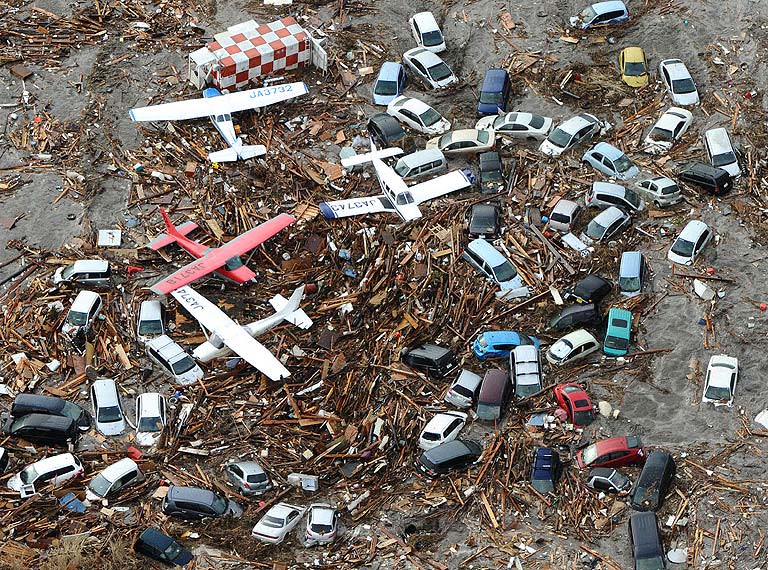 Light planes and vehicles sit among the debris after they were swept by a tsumani that struck Sendai airport in northern Japan.