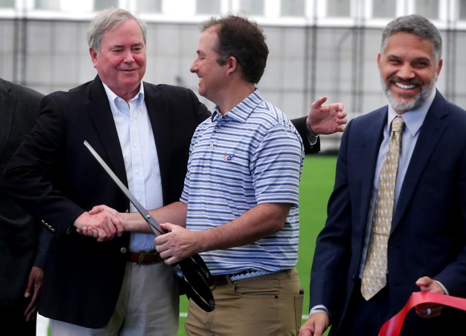 John Snyder, President and Chairman of the Tennessee State Soccer Association, left, shakes the hand of Murfreesboro Mayor Shane McFarland as part of the ribbon-cutting ceremony for the Siegel Park Indoor Soccer Park facility on Friday, March 24, 2023. Hans Hobson, CEO of the Tennessee State Soccer Association, far right smiles after participating in the ribbon-cutting ceremony.