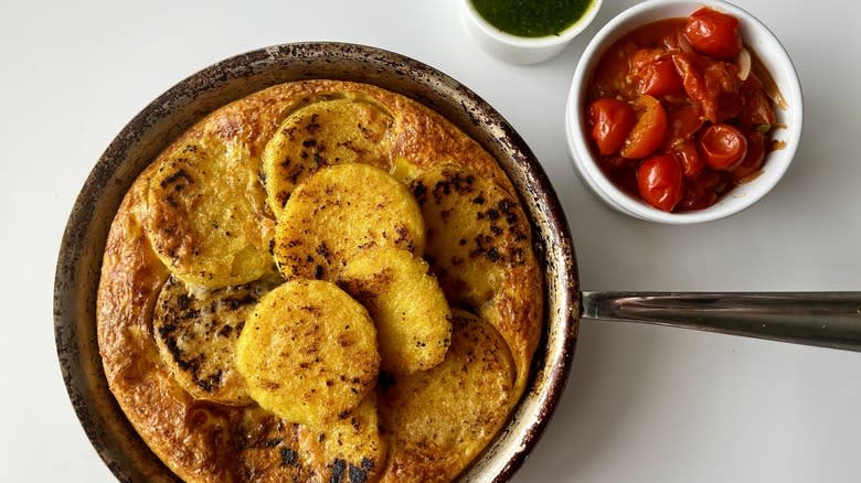 fried polenta frittata in a skillet with tomato sauce