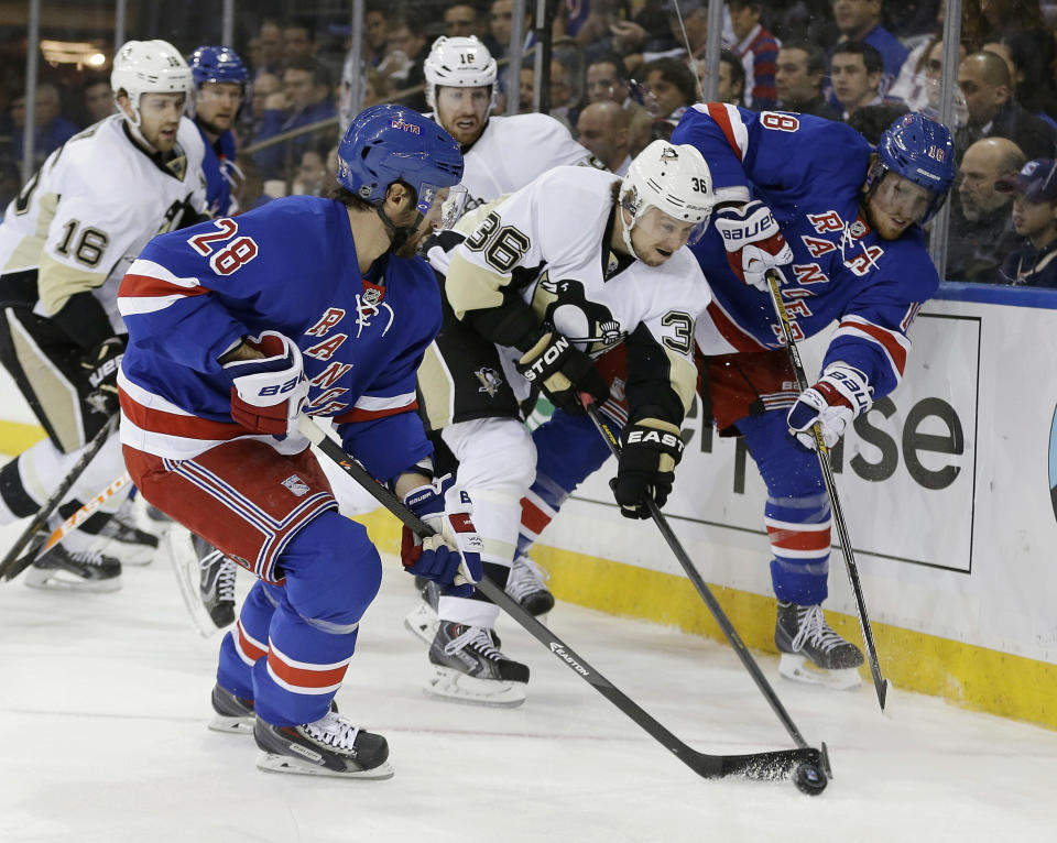 Pittsburgh Penguins' Jussi Jokinen (36), of Finland, fights for control of the puck with New York Rangers' Dominic Moore (28) and Marc Staal (18) during the first period of a second-round NHL Stanley Cup hockey playoff series Wednesday, May 7, 2014, in New York. (AP Photo/Frank Franklin II)