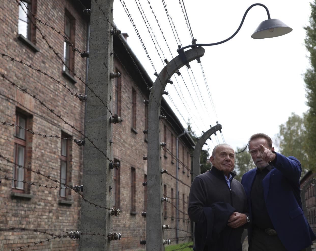 Arnold Schwarzenegger, right, and Simon Bergson, chairman of The Auschwitz Jewish Center Foundation visit Auschwitz - Birkenau Nazi German death camp in Oswiecim, Poland, Wednesday, Sept. 28, 2022. Film icon Schwarzenegger visited the site of the Nazi German death camp Auschwitz on Wednesday to send a message against hatred. The "Terminator" actor was given a tour of the site, viewing the barracks watchtowers and the remains of gas chambers that endure as evidence of the German extermination of Jews, Roma and others during World War II. (AP Photo/Michal Dyjuk)