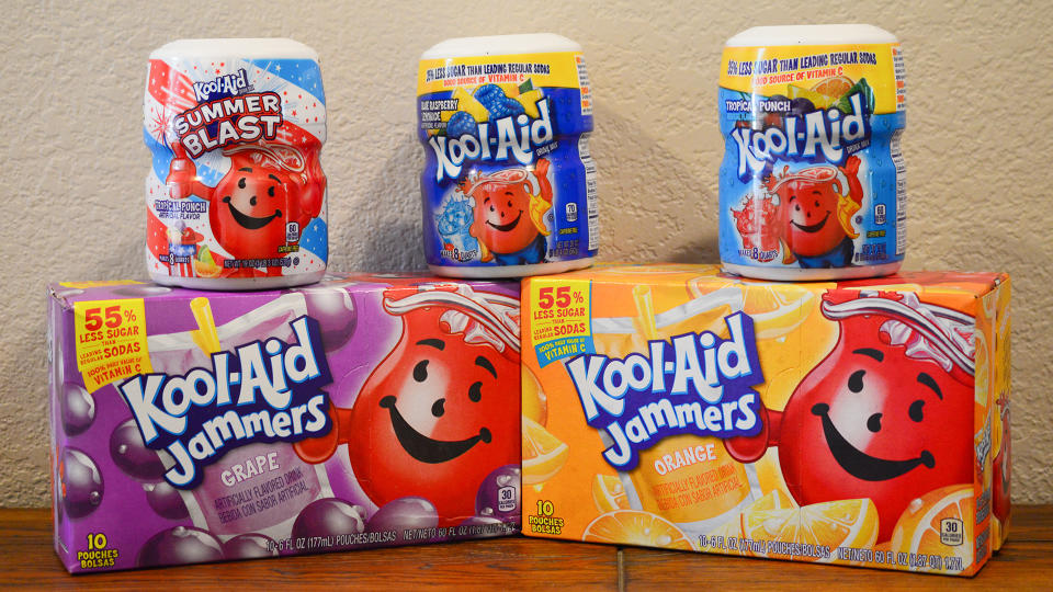 Norman, OK June 20, 2018 Close up photo of a grape and orange Kool-Aid Jammers box and three different flavors of Kool-Aid drink mixes on a wooden table with a white background.