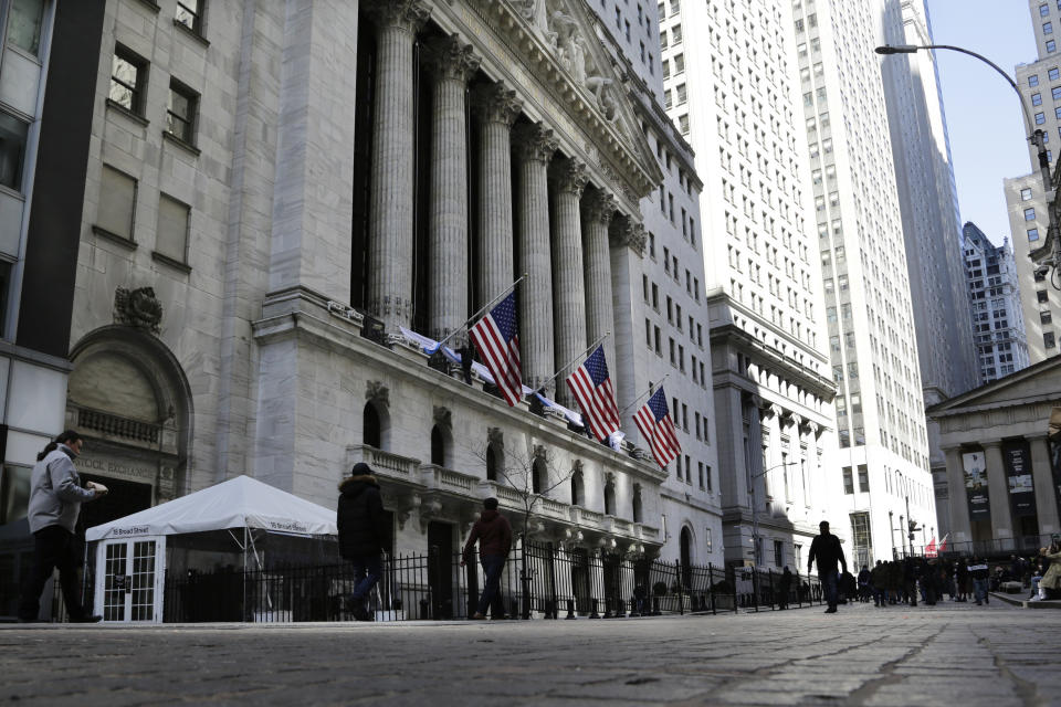 People pass the front of the New York Stock Exchange in New York, Tuesday, March 21, 2023. Stocks are rising on Wall Street, including the banks most beaten down by the industry's crisis. (AP Photo/Peter Morgan