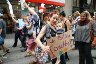 <p>Kate Marx and her son Thulson from Sunnyside, Queens, participate in a rally along 42nd Street in New York City on June 20, 2018. (Photo: Gordon Donovan/Yahoo News) </p>