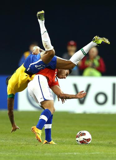 El centrocampista brasileño Luiz Gustavo cae encima del delantero de Chile Eduardo Vargas durante un lance del partido amistoso entre Brasil y Chile disputado en Toronto, Canadá, el martes 19 de noviembre de 2013 (Getty/AFP | Elsa)