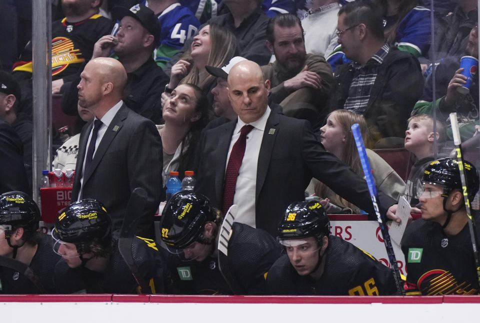 Vancouver Canucks coach Rick Tocchet, center, stands behind the bench during the third period of the team's NHL hockey game against the Vegas Golden Knights on Tuesday, March 21, 2023, in Vancouver, British Columbia. (Darryl Dyck/The Canadian Press via AP)