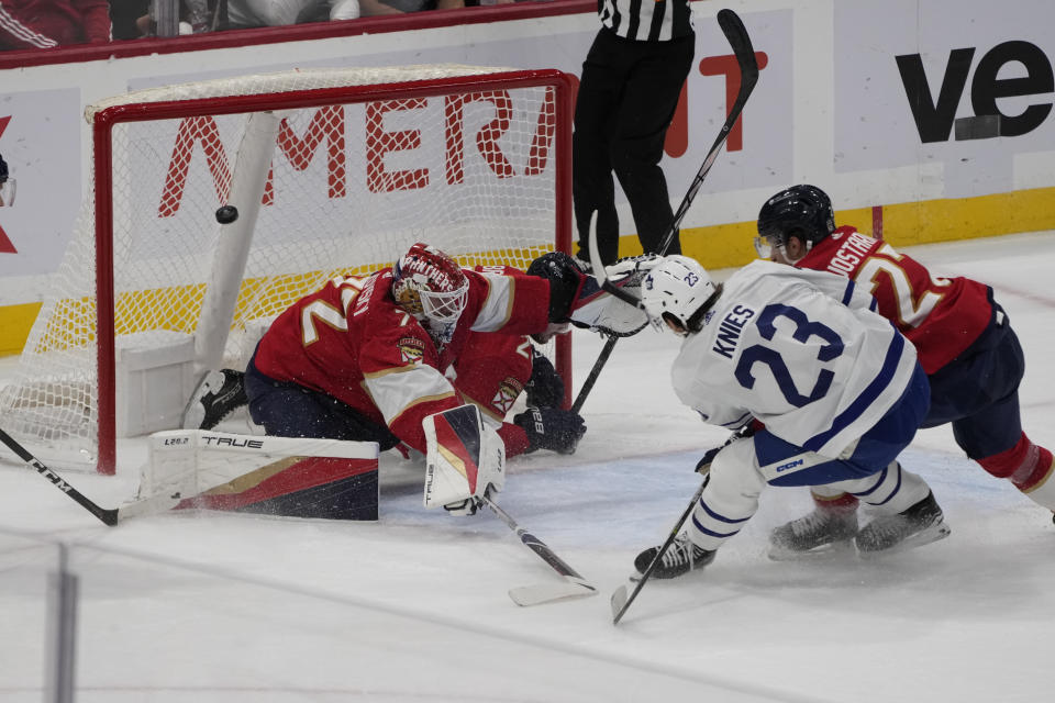 Toronto Maple Leafs left wing Matthew Knies (23) shoots into the net as Florida Panthers defenseman Uvis Balinskis (26) is tripped into the net during the second period of an NHL hockey game, Thursday, Oct. 19, 2023, in Sunrise, Fla. The goal was nullified. (AP Photo/Marta Lavandier)