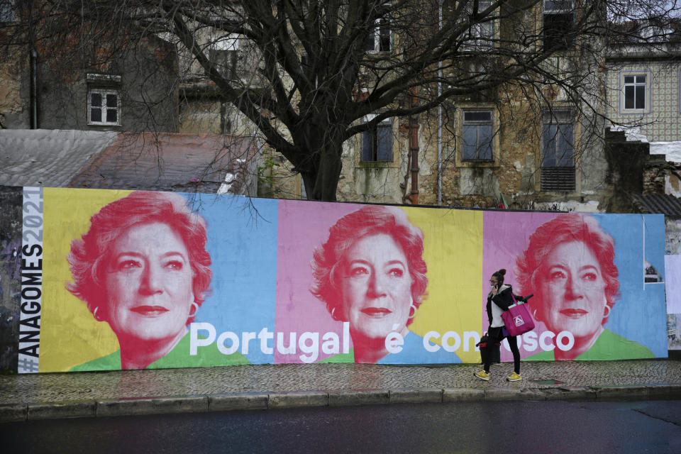 A woman walks past election campaign posters for presidential candidate Ana Gomes, in Lisbon, Wednesday, Jan. 20, 2021.Portugal holds a presidential election on Sunday, Jan. 24, 2021 and the moderate incumbent candidate is widely seen as the sure winner. But an intriguing question for many Portuguese is how well a brash new populist challenger fares in the ballot. Mainstream populism is a novelty in Portugal. (AP Photo/Armando Franca)