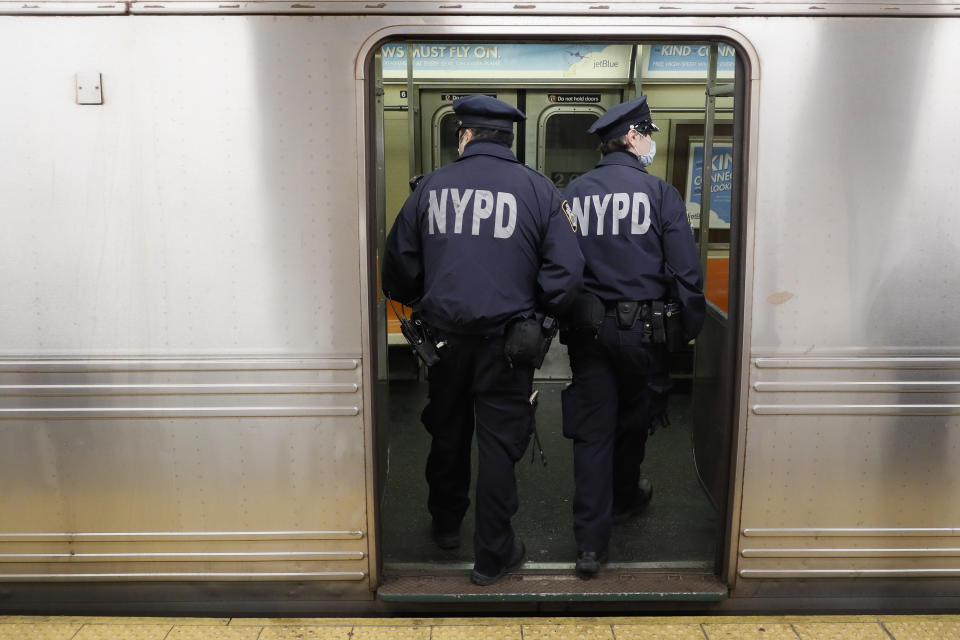 NYPD officers wake up sleeping passengers and direct them to the exits at the 207th Street A-train station, Thursday, April 30, 2020, during the coronavirus pandemic, in the Manhattan borough of New York. (AP Photo/John Minchillo)