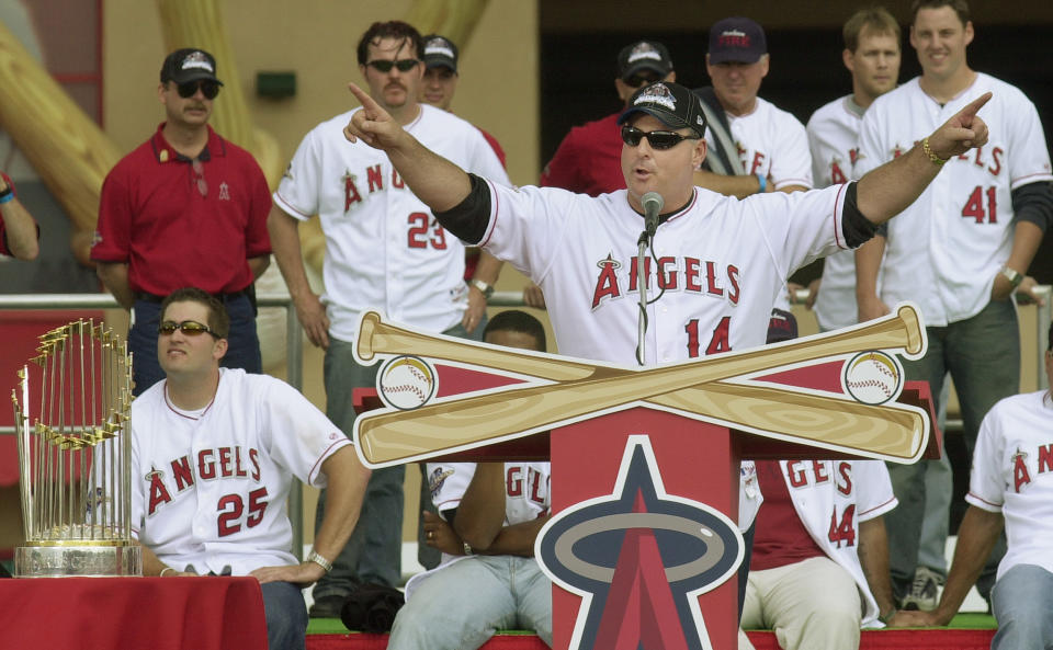 With the World Series championship trophy at left, Anaheim Angels manager Mike Scioscia talks to thousands of cheering fans during the celebration of the Anaheim Angels' World Series championship Tuesday, Oct. 29, 2002, at Edison International Field in Anaheim, Calif.  From left are Most Valuable Player Troy Glaus (25), Scott Spiezio (23) and pitcher John Lackey (41)  (AP Photo/Reed Saxon)