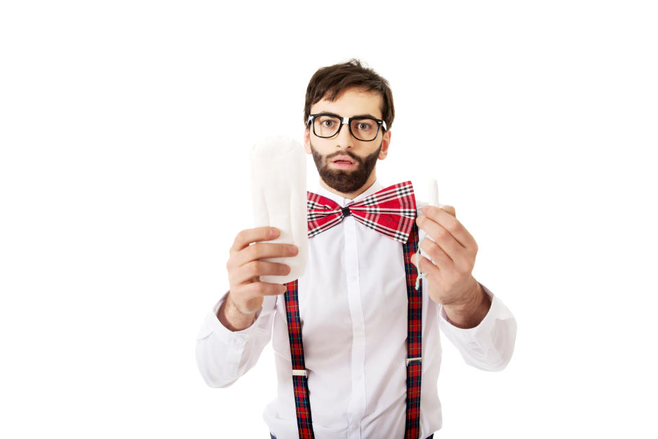 Man Holding Tampon And Padding While Standing Against White Background