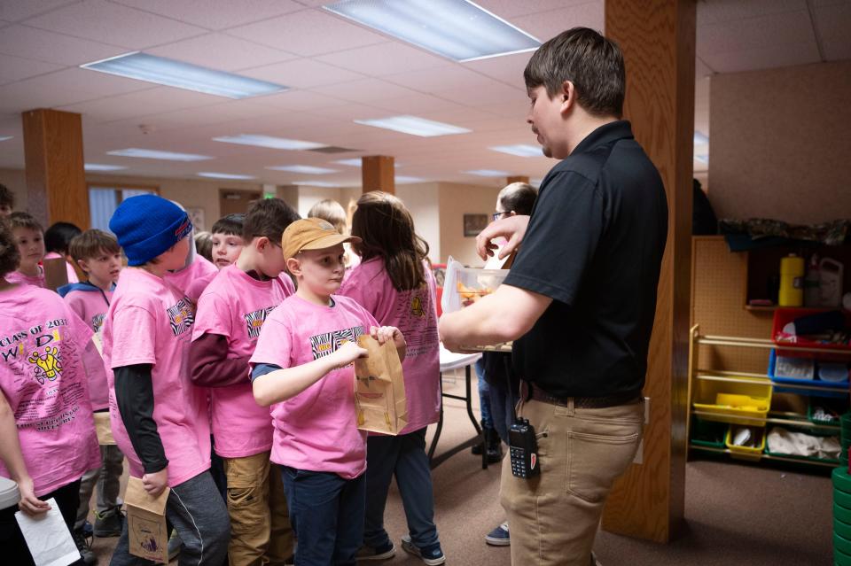 Zoo education programs manager Alex Case helps fifth grade students from Marshall's Gordon Elementary School put together enrichment items for prairie dogs at Binder Park Zoo on Friday, Feb. 2, 2024.