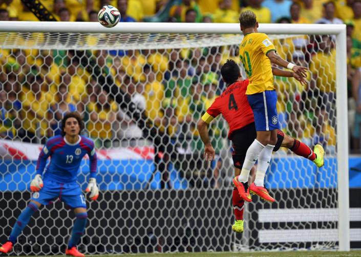 Brazil's forward Neymar (R) and Mexico's defender Rafael Marquez (C) jump for the ball in front of Mexico's goalkeeper Guillermo Ochoa during a World Cup match in Fortaleza on June 17, 2014 (AFP Photo/Odd Andersen)