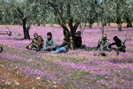 Turkish-backed Free Syrian Army fighters rest in a field in eastern Afrin, Syria March 9, 2018. REUTERS/Khalil Ashawi