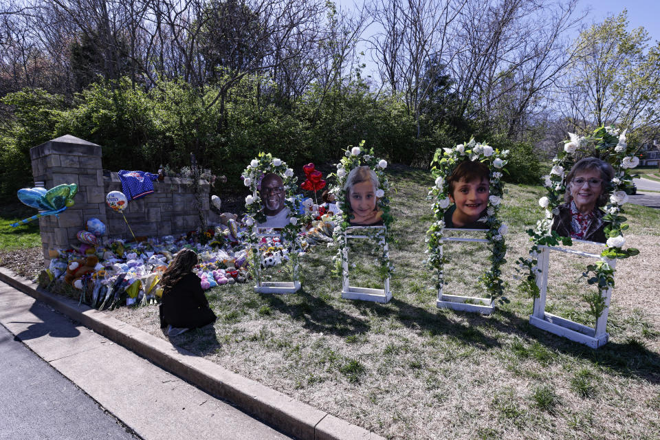 FILE - A woman prays near the likeness of four of the victims as she visits a memorial at the entrance to The Covenant School on Wednesday, March 29, 2023, in Nashville, Tenn. In Tennessee, a request for police to release a school shooter’s private writings has morphed into a complex multiparty legal fight. With no national standard over how to treat such records, both sides claim their position is in the public interest. (AP Photo/Wade Payne, File)