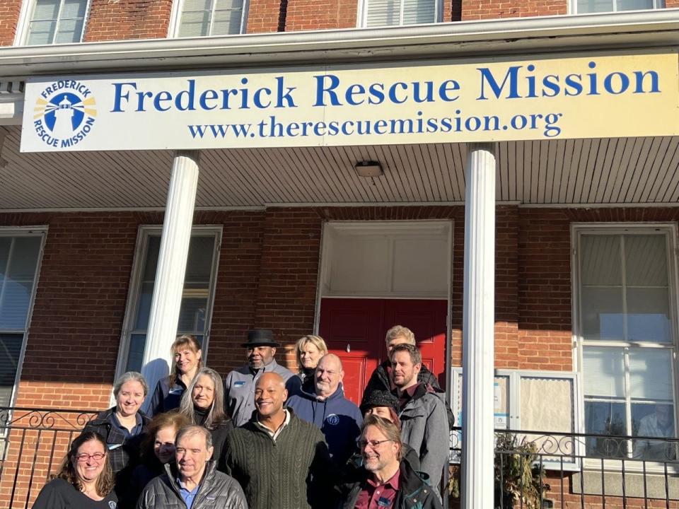 Gov.-Elect Wes Moore, center (green sweater), stands with the staff of the Frederick Rescue Mission on the steps of their building in Frederick, Maryland on Jan. 16, 2023. The mission was Moore's first stop on the Martin Luther King Jr. National Day of Service.