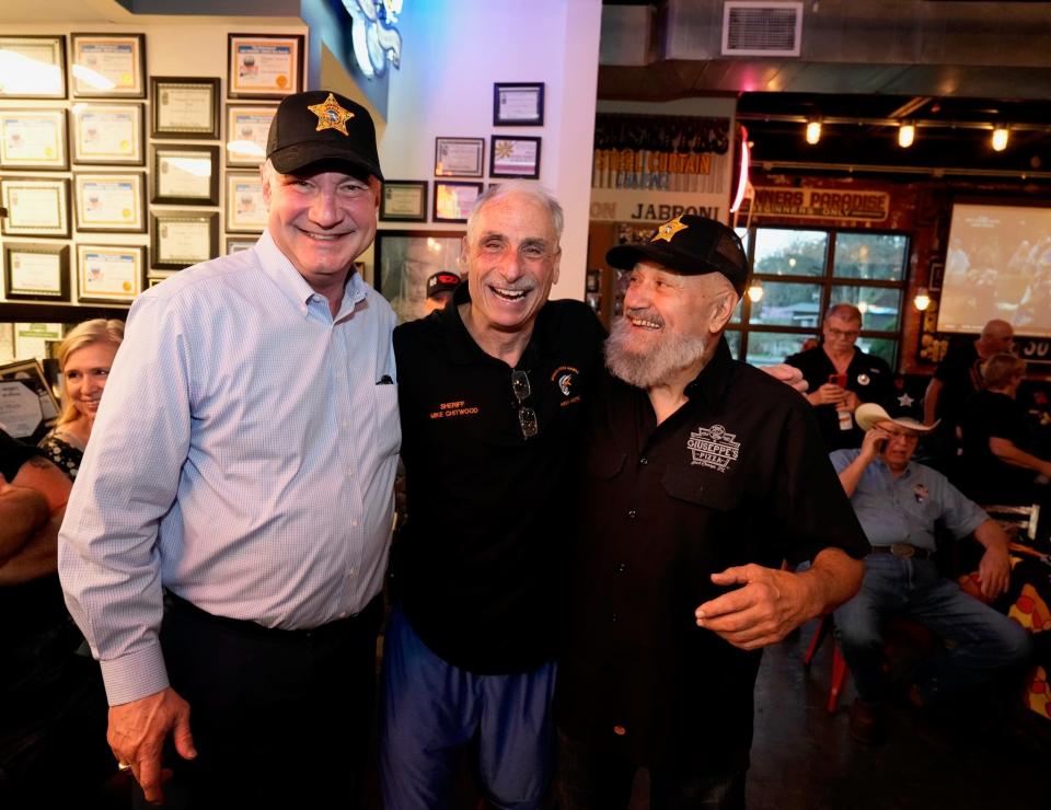 Halifax Health CEO Jeff Feasel, Volusia Sheriff Mike Chitwood and Giuseppe's loyalist Al Balboa pose after making winning bids on autographed Volusia Sheriff's hats during a benefit auction to support cancer treatments for 10-year-old Jenna Teachman of Port Orange.