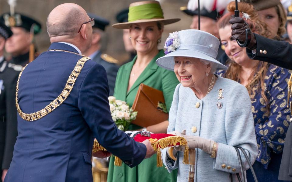 The Queen donned a powder blue coat and hat adorned with purple and white flowers at the Ceremony of the Keys - Jane Barlow 