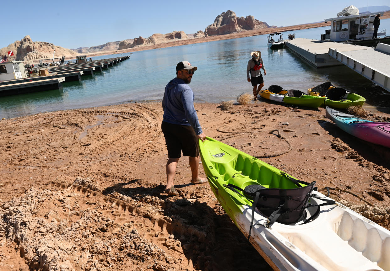 Nick Messing pull a kayaks down to the waters edge at Wahweap Marina at Lake Powell on April 6, 2022 in Page, Arizona when water levels at Lake Powell were at a historic low. (Photo by  RJ Sangosti/MediaNews Group/The Denver Post via Getty Images)