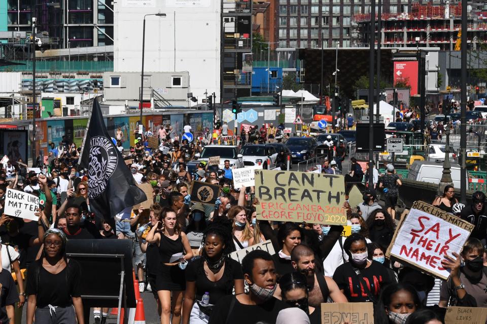 Demonstrators carry placards as they march in the road near the U.S. Embassy in central London on Sunday.  (Photo: DANIEL LEAL-OLIVAS via Getty Images)