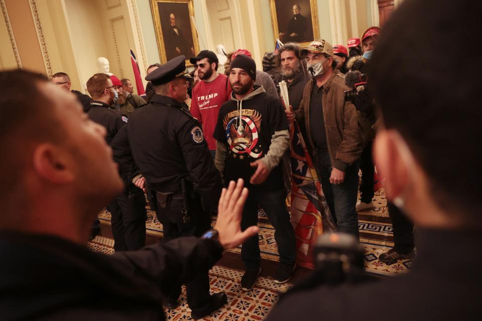 Trump supporters talk with Capitol Police inside the building.