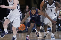 Connecticut guard R.J. Cole (2) comes up with the ball between Butler's Bo Hodges (1) and Simas Lukosius (41) in the second half of an NCAA college basketball game in Indianapolis, Thursday, Jan. 20, 2022. (AP Photo/AJ Mast)